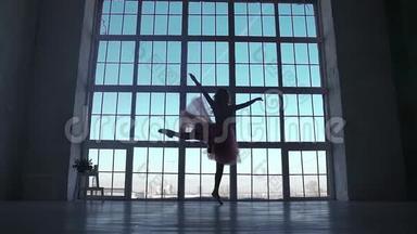 大窗户背景上芭蕾舞演员的<strong>剪影</strong>。 芭蕾舞演员穿着尖角鞋旋转。 <strong>剪影</strong>